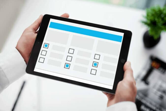 Mann holder ipad som vider evalueringer etter pandemi