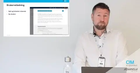 A man stands next to a screen displaying a presentation slide in Norwegian. He's wearing a white shirt and lanyard. The slide includes a webpage screenshot and text about a user manual. A laptop, water bottle, and branding logos are visible.