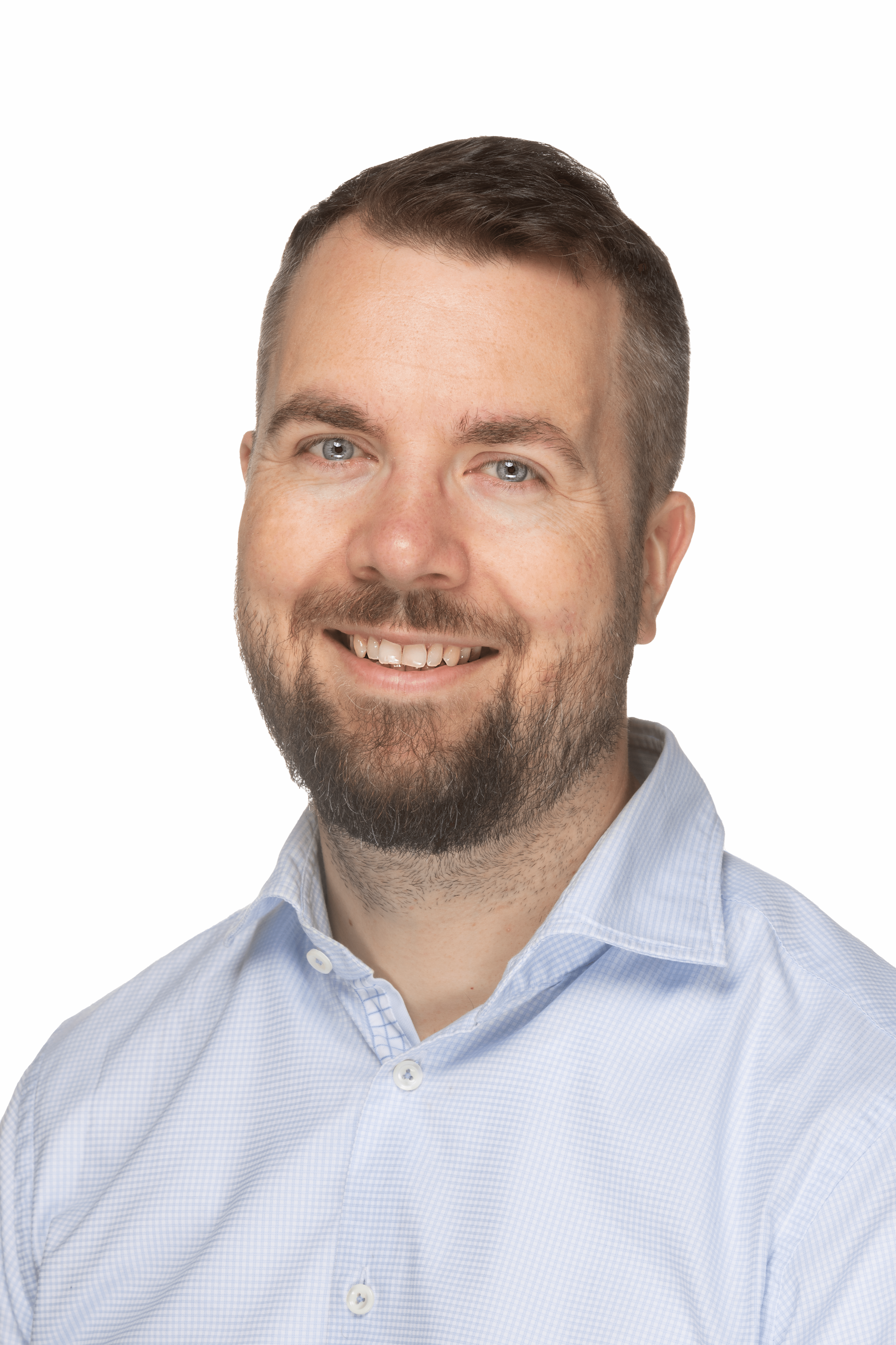 Ein lächelnder Mann mit kurzen braunen Haaren und einem Bart, der ein hellblaues Hemd mit Kragen trägt, posiert vor einem einfarbigen hellrosa Hintergrund und repräsentiert F24 Norge AS.