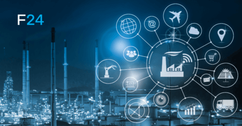 In einer nächtlichen Industrielandschaft sind leuchtende Fabriksymbole und Technologiesymbole wie ein Globus, ein Flugzeug und Zahnräder miteinander verbunden und symbolisieren die industrielle Konnektivität und die Weiterentwicklung von Alarm- und Krisenmanagementlösungen. In der oberen linken Ecke wird „F24“ angezeigt.