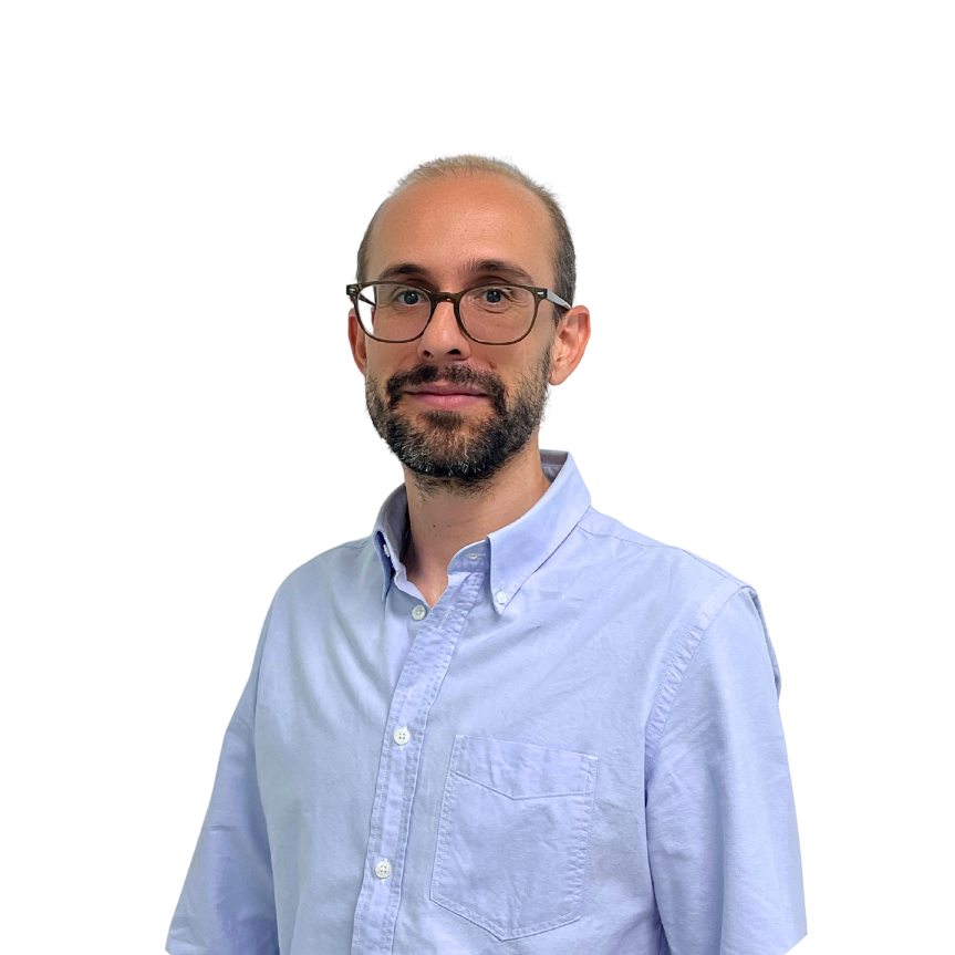 A man with glasses, short hair, and a beard is wearing a light blue button-up shirt. He stands against a plain white background, looking at the camera with a slight smile—ready for the Seminario Web: Alertar de forma temprana ante desastres naturales.