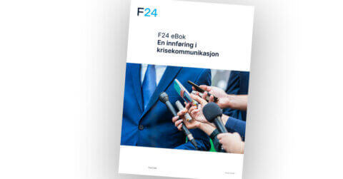 Cover of an eBook titled “F24 eBok En innføring i krisekommunikasjon” with a photo of people holding microphones towards a person in a suit, suggesting a press interview or media briefing.