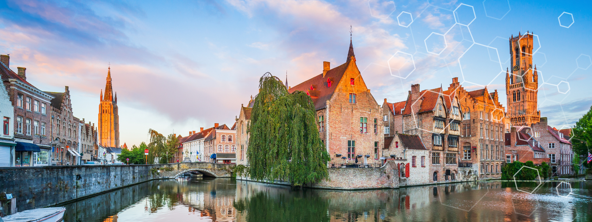 Scenic view of historic buildings and towers along a canal in Bruges, Belgium at sunset, with a tree and reflection in the water; abstract hexagonal patterns overlay the sky.