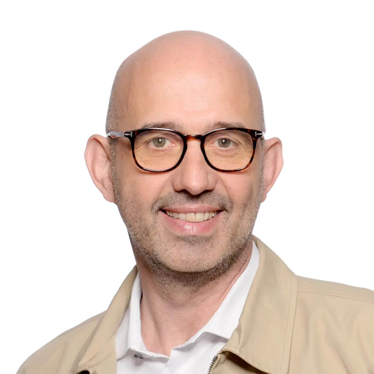 Hombre calvo sonriente con gafas, vestido con chaqueta beige y camisa blanca, de frente sobre un fondo liso.