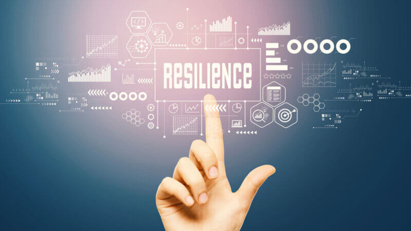 A hand points at the word "RESILIENCE" on a virtual screen, surrounded by digital data graphics and charts, symbolizing strength, datasikkerhet, data analysis, and progress.