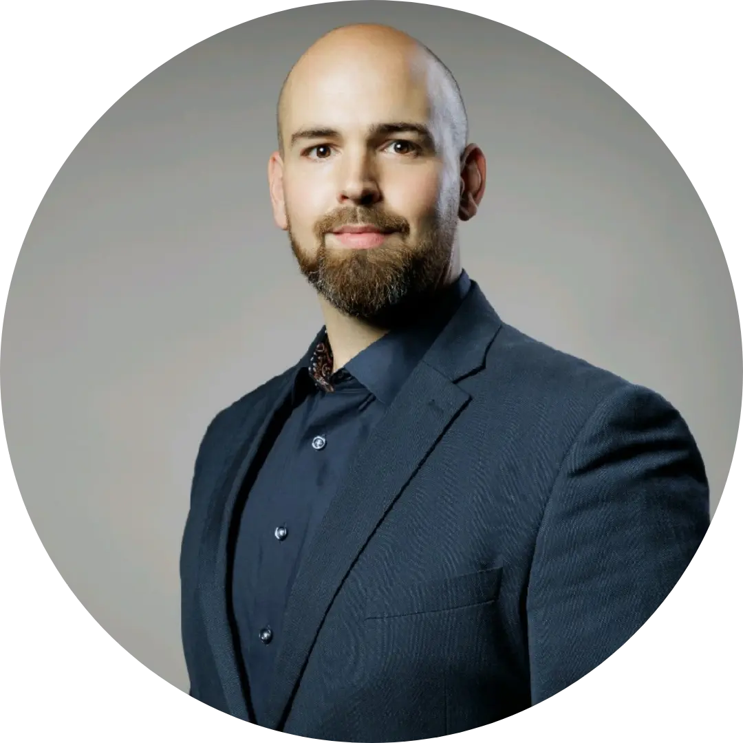 Ein Mann mit Glatze und Bart, gekleidet in einem dunkelblauem Anzug und marineblauem Hemd posiert selbstbewusst vor einem schlichten, hellgrauen Hintergrund und wirbt für das Webinar von Garandus & der GRC-Software TopEase von F24.