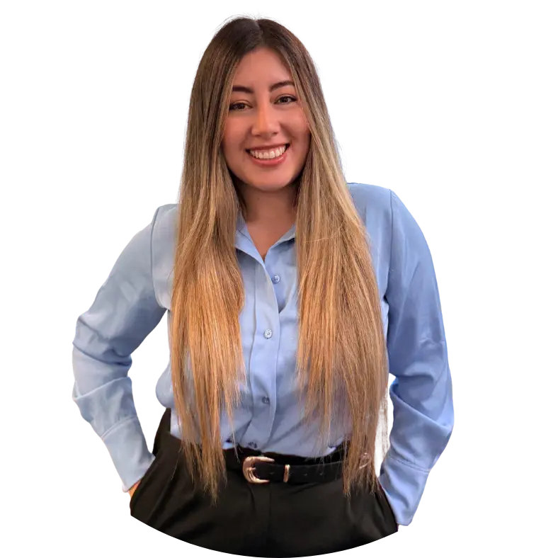 A woman with long, straight hair wears a light blue button-up shirt and black pants. She is smiling and standing with her hands on her hips against a plain white background, as if ready to host a Petrofac webinar or share her contacto details.