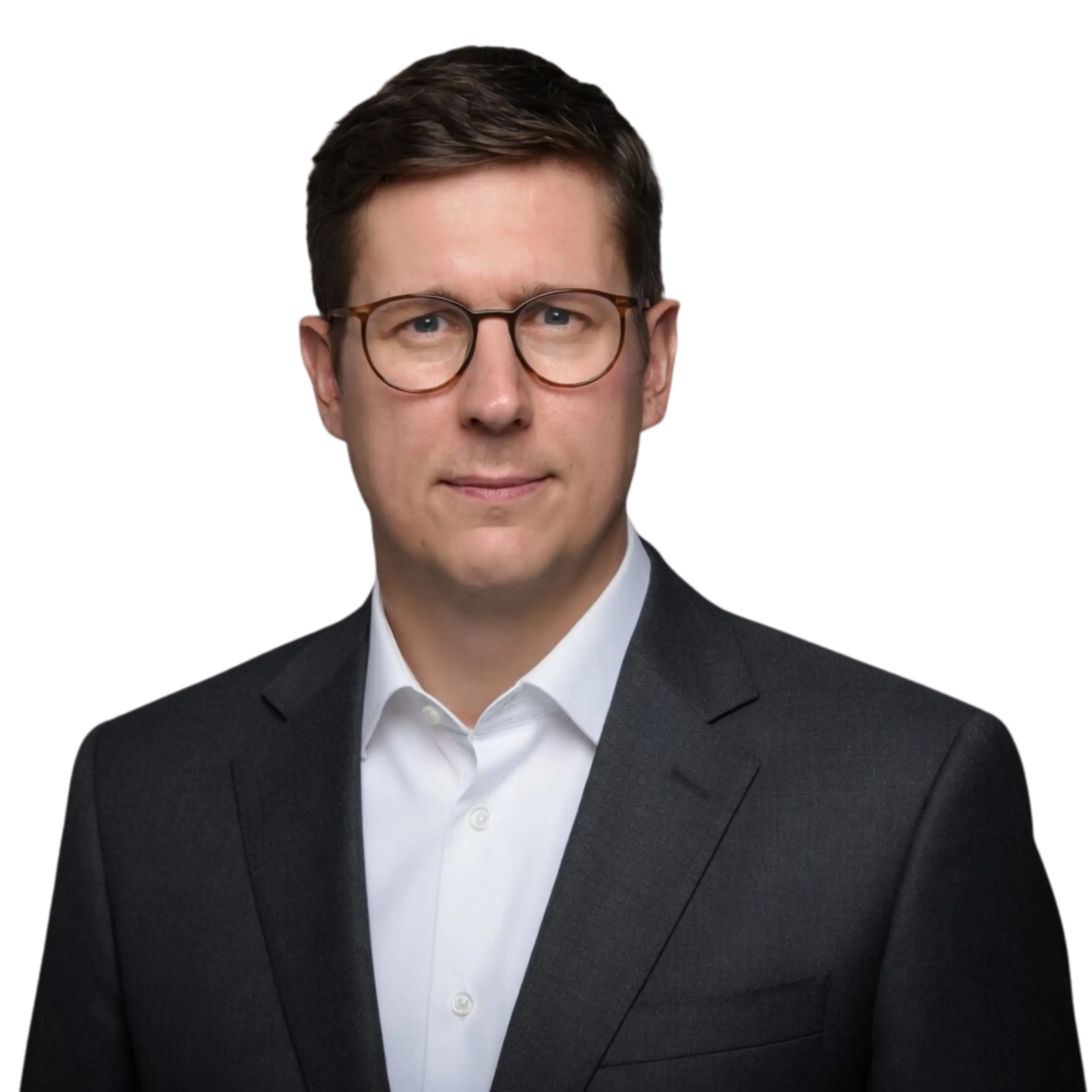 A man with short brown hair wearing glasses, a white dress shirt, and a dark suit jacket poses against a plain white background.